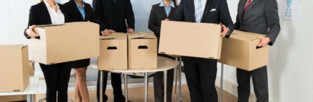 Groupe de collaborateurs tenant des cartons, prêts pour déménager.